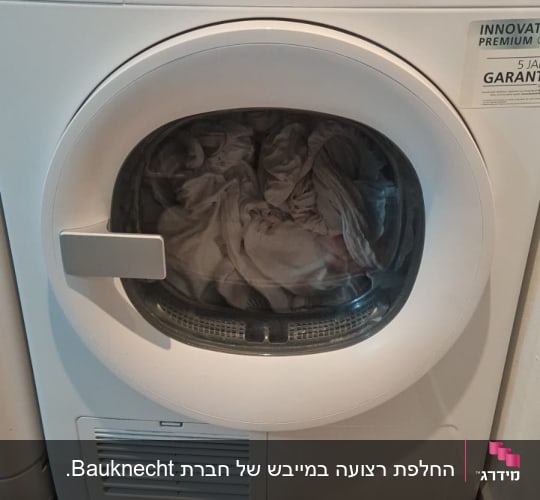 מכונת כביסה עם בגדים בתוף ותצוגה דיגיטלית